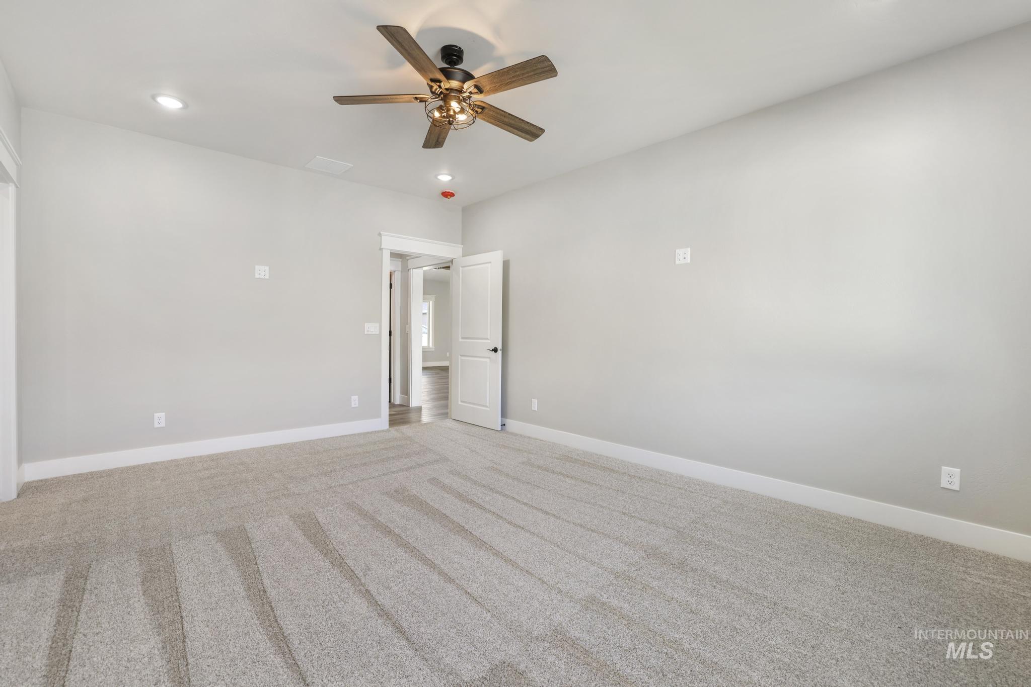 298 Sandi Road Twin Falls, ID 83301 - Photo 14 of 24 Spacious room featuring light grey carpeting, recessed lighting, white trim, and a ceiling fan with a bronze finish