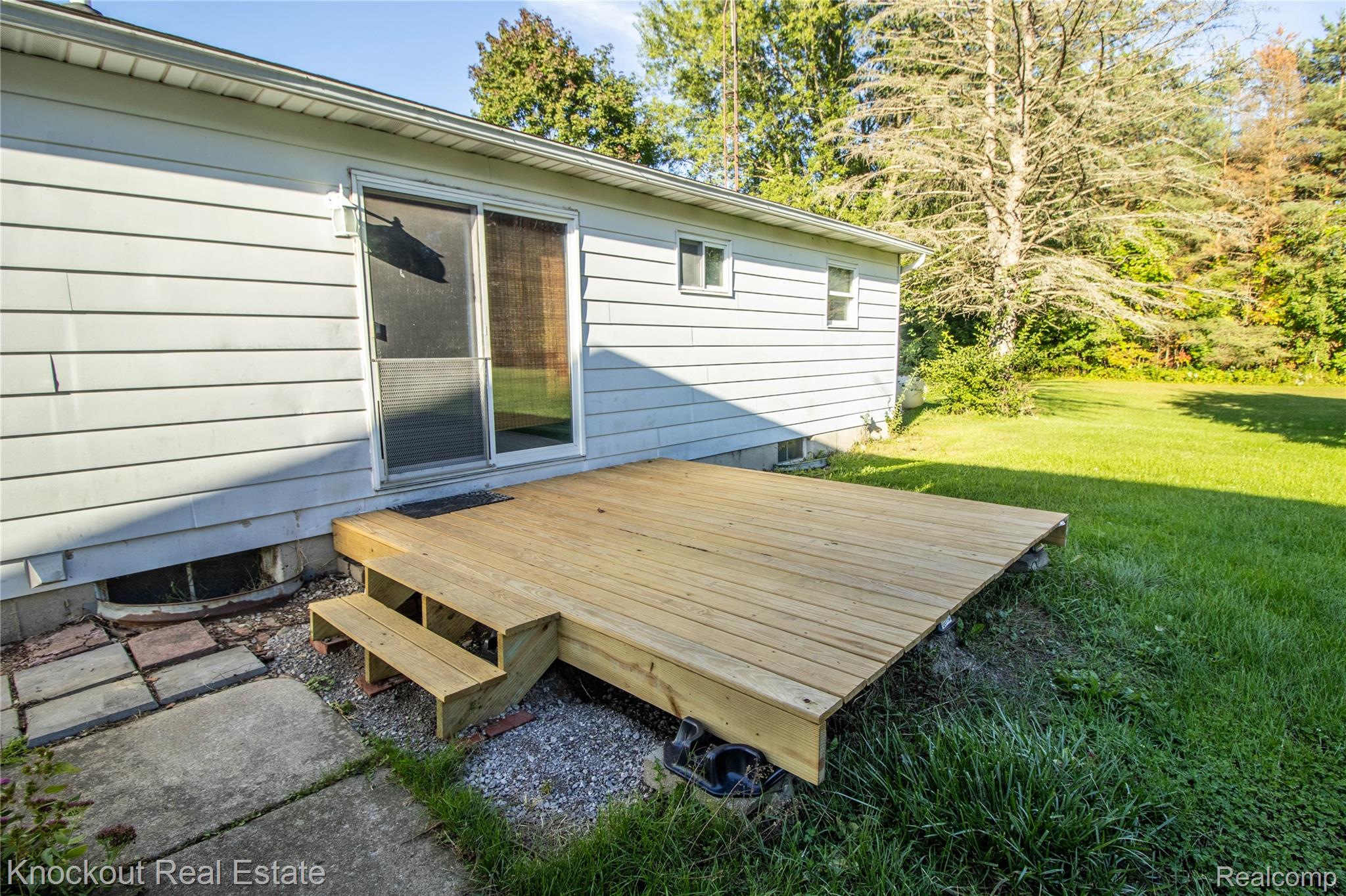 5796 East Burt Road Birch Run, MI 48415 - Photo 32 of 41 Rear exterior featuring light-colored siding, a sliding glass door, and an attached wood deck with steps