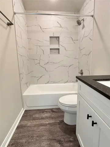 a bathroom with a white toilet and a bathtub