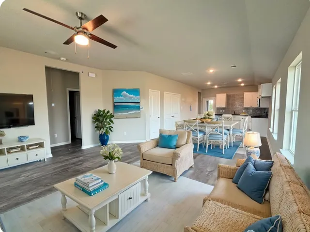 a living room with furniture kitchen view and a window