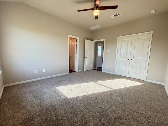 a view of an empty room with a ceiling fan