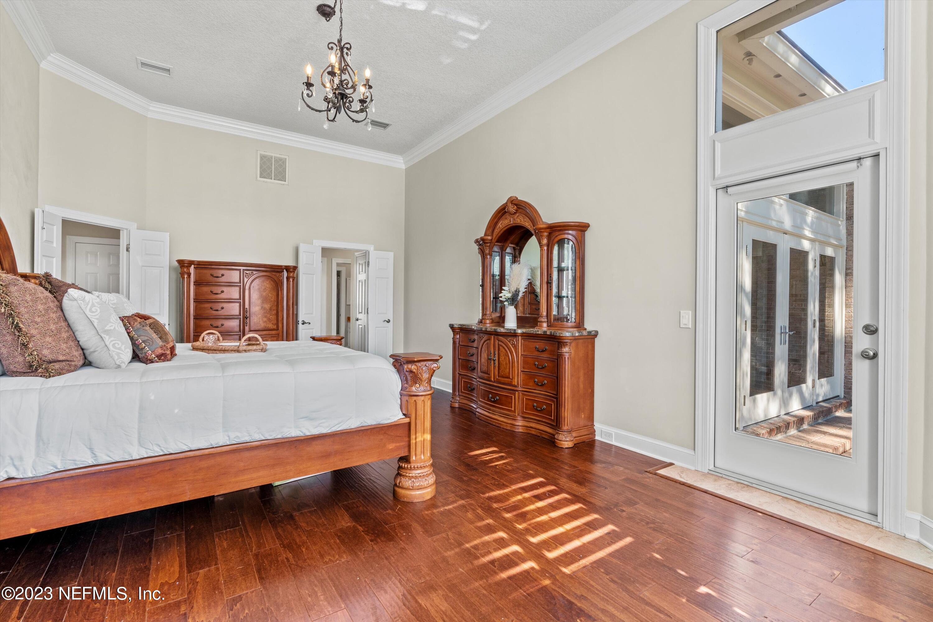 13062 Biggin Church Road South Jacksonville, FL 32224 - Photo 15 of 56 a bed room with a bed and a chandelier