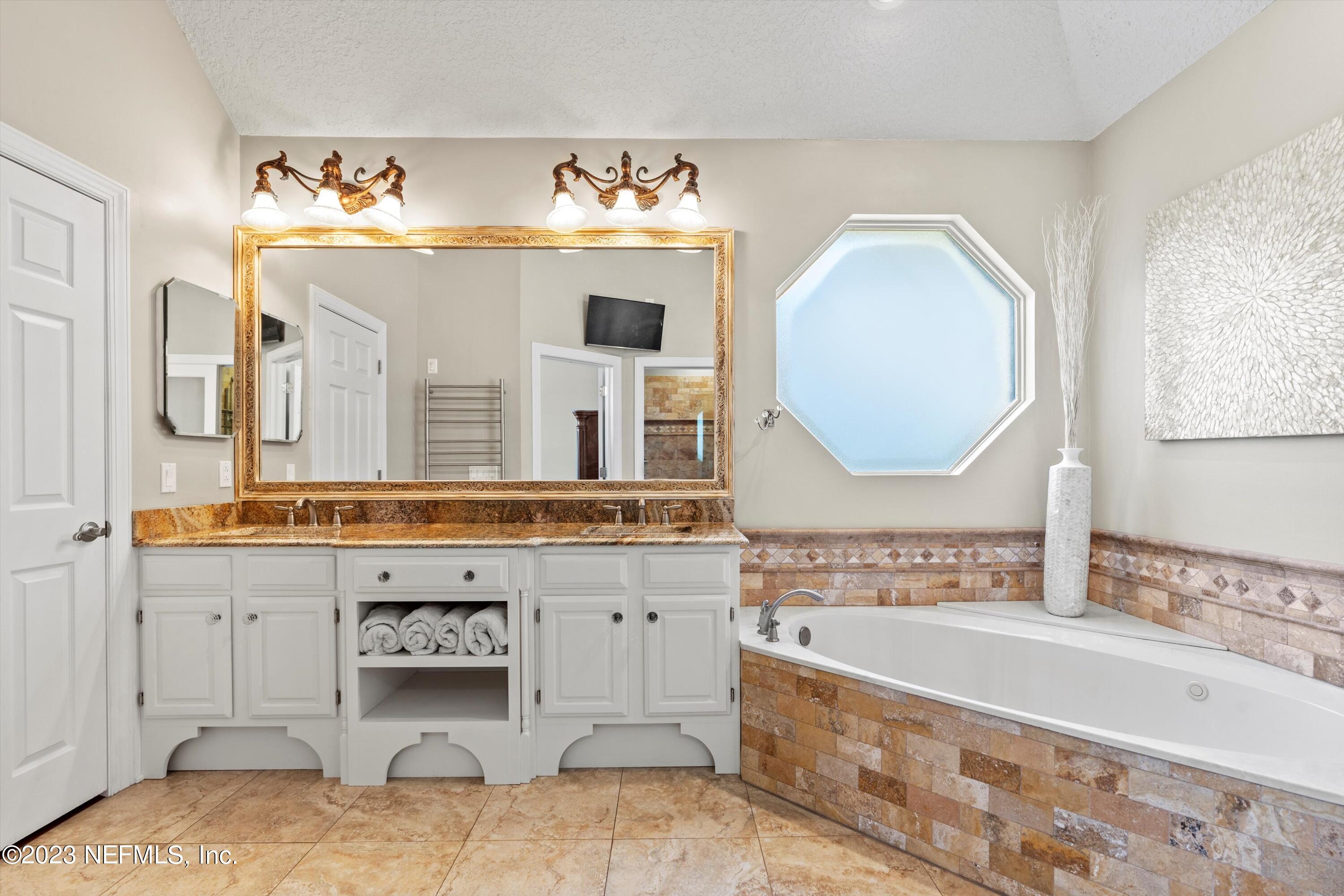 13062 Biggin Church Road South Jacksonville, FL 32224 - Photo 16 of 56 a spacious bathroom with a tub sink and mirror