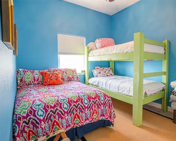a bedroom with two beds and a painting on the wall