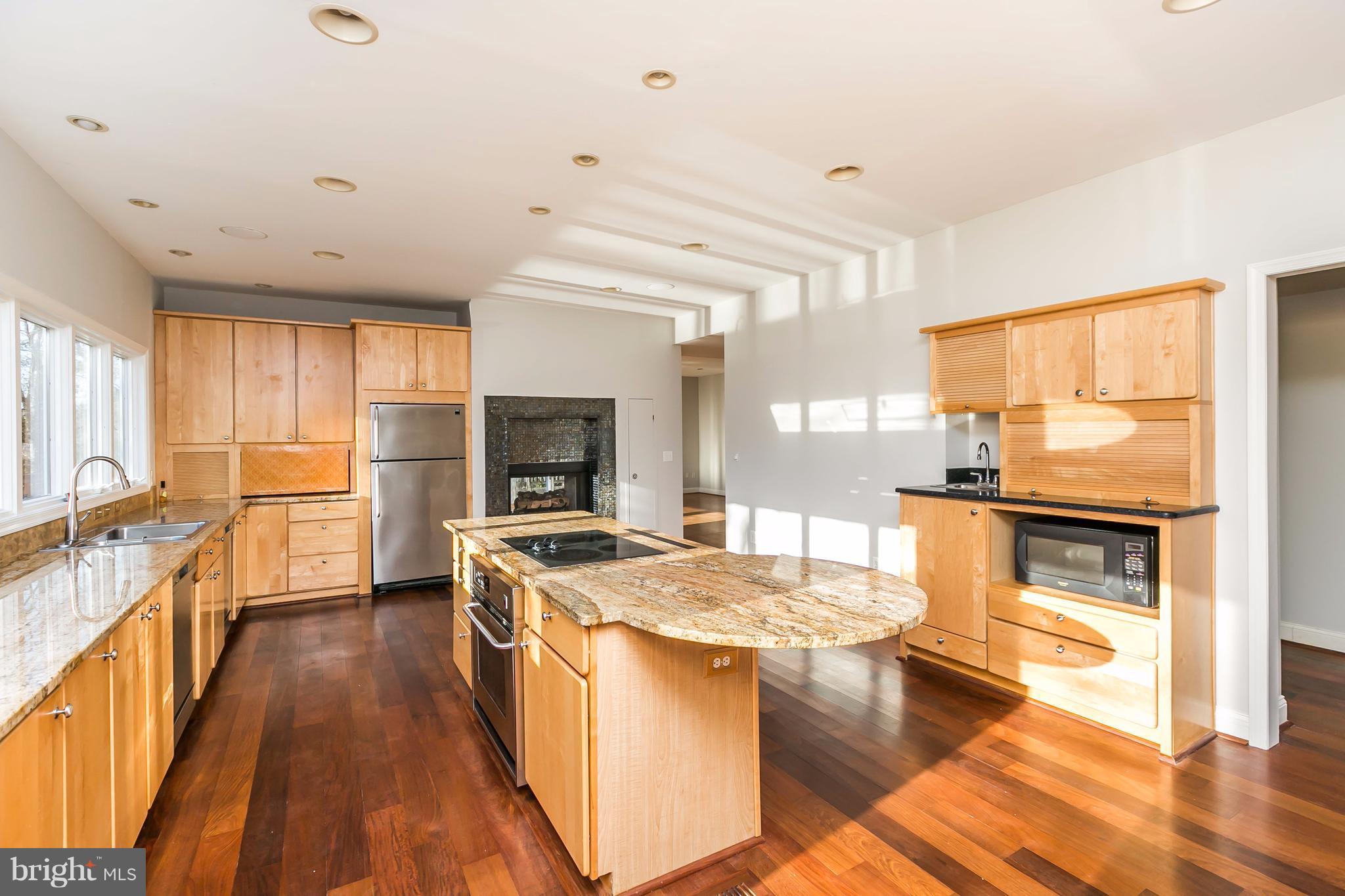 126 Gilbert Court Edgewater, MD 21037 - Photo 8 of 30 a kitchen with a stove top oven a sink a dining table and chairs