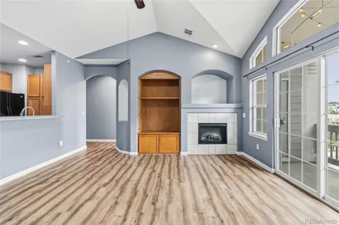 a view of a kitchen with kitchen island wooden floors stainless steel appliances and windows