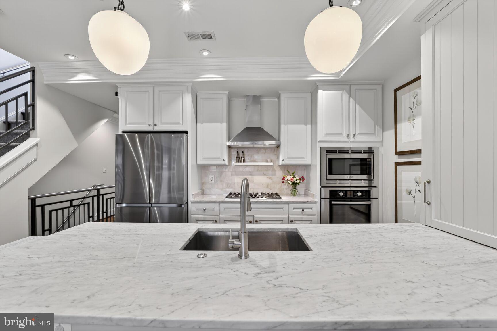 2446 Ontario Road Northwest, Unit 4 Washington, DC 20009 - Photo 10 of 65 a kitchen with stainless steel appliances kitchen island granite countertop a stove a sink and a refrigerator