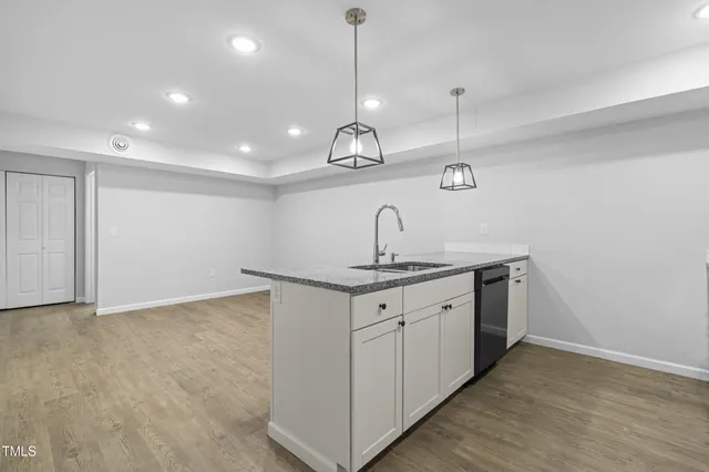 a kitchen with stainless steel appliances granite countertop a refrigerator a stove a sink dishwasher a refrigerator with a dining table and chairs