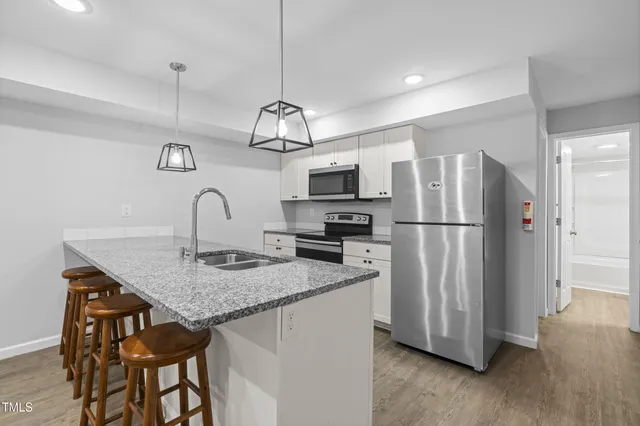 a kitchen with stainless steel appliances granite countertop a sink and a refrigerator
