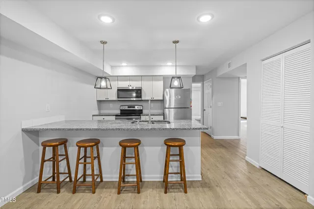 a view of kitchen with kitchen island stainless steel appliances refrigerator sink and microwave