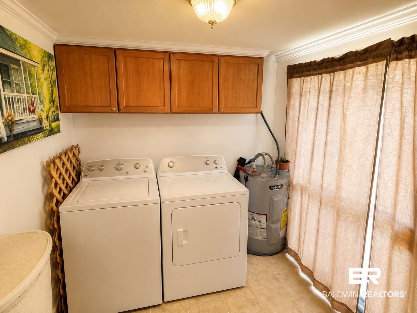 1950 Ryders Lane Mobile, AL 36605 - Photo 12 of 18 Laundry area featuring light wood-finish cabinetry, crown molding, and tile flooring