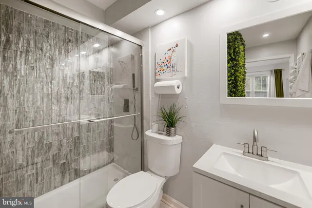 a white toilet sitting next to a bathroom sink