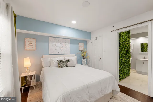 a bedroom with a bed and a potted plant