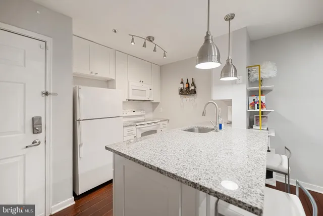 a kitchen with stainless steel appliances granite countertop a sink a refrigerator and a stove