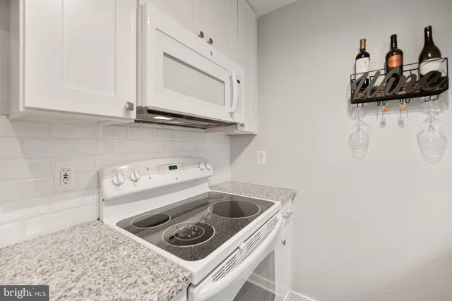 a kitchen with a stove and a white sink