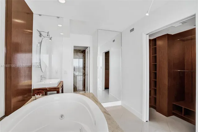 a spacious bedroom with a bed and a shower