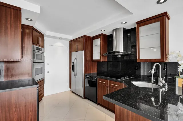a kitchen with granite countertop a refrigerator stove and sink
