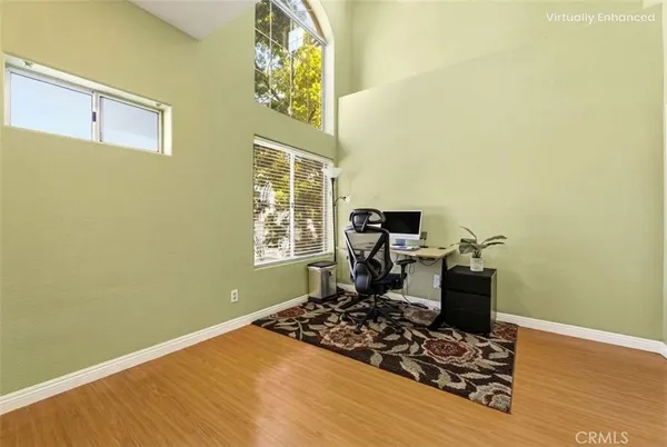 a view of a workspace with wooden floor and a window
