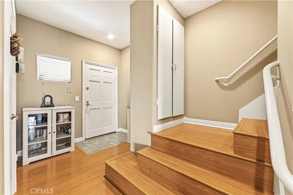 a view of a bedroom with wooden floor and stairs