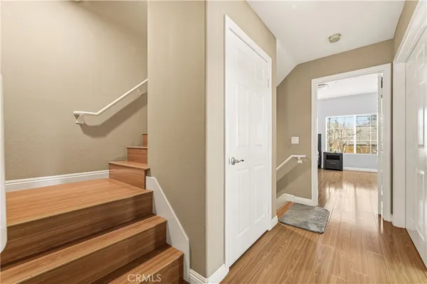 a view of a hallway with wooden floor and staircase