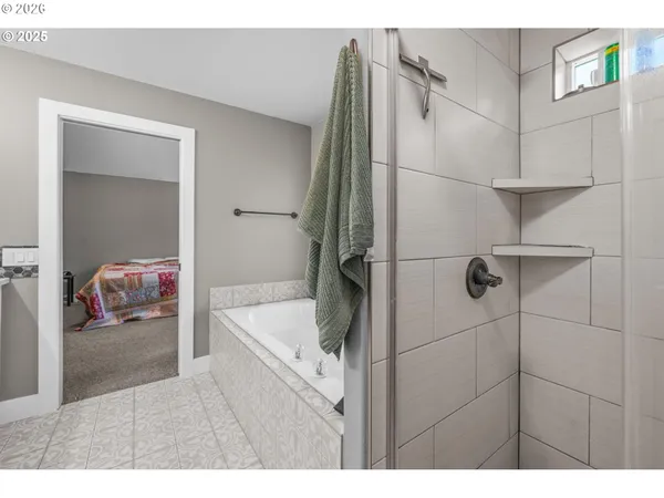 a bathroom with a tub sink shower and mirror