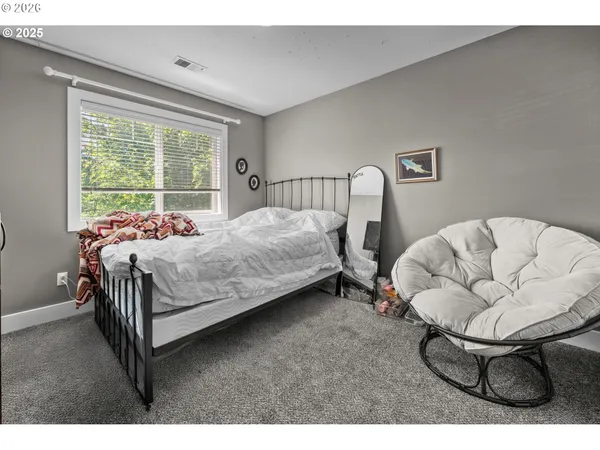 a bedroom with a bed chair and window