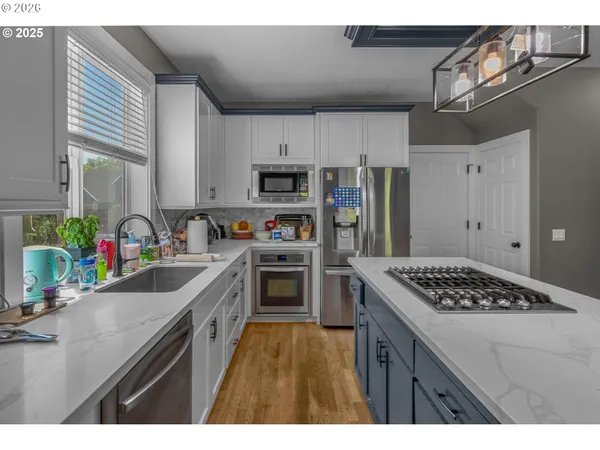 a kitchen with stainless steel appliances kitchen island a sink stove and refrigerator