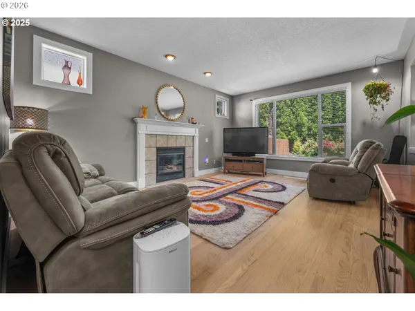 a living room with furniture fireplace and a large window