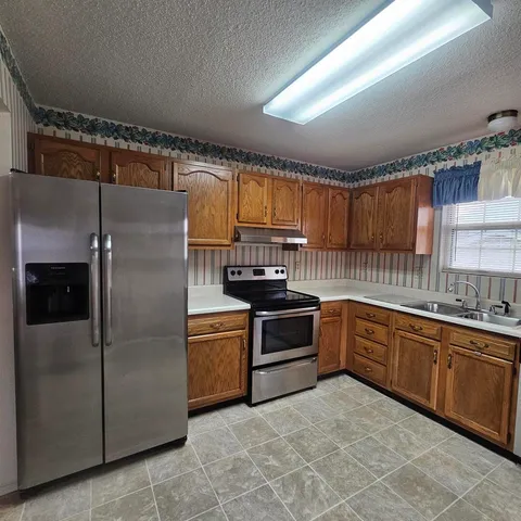 a kitchen with stainless steel appliances a sink stove and cabinets