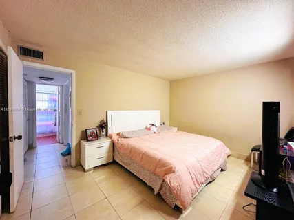 a bedroom with a bed and a potted plant