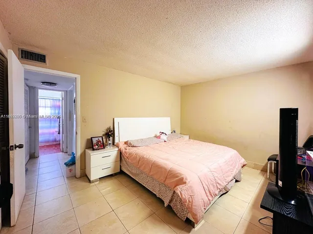 a bedroom with a bed and a potted plant