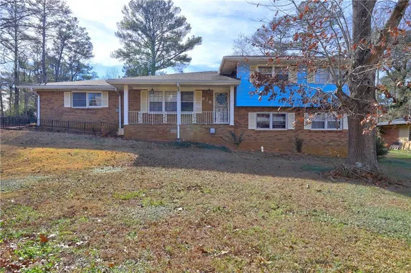 a view of a house with a yard and sitting area