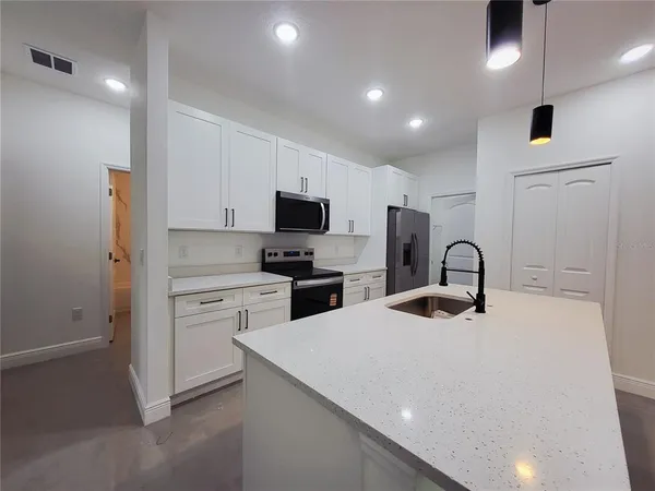 a kitchen with white cabinets and stainless steel appliances