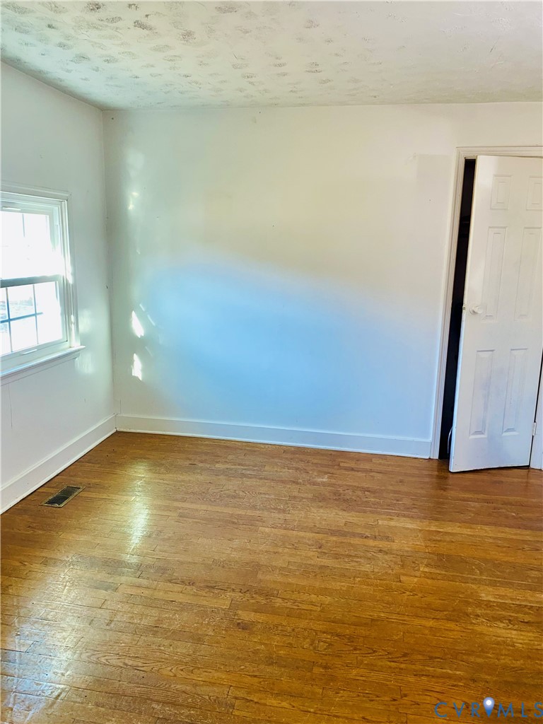 Spare room featuring wood-type flooring and a text