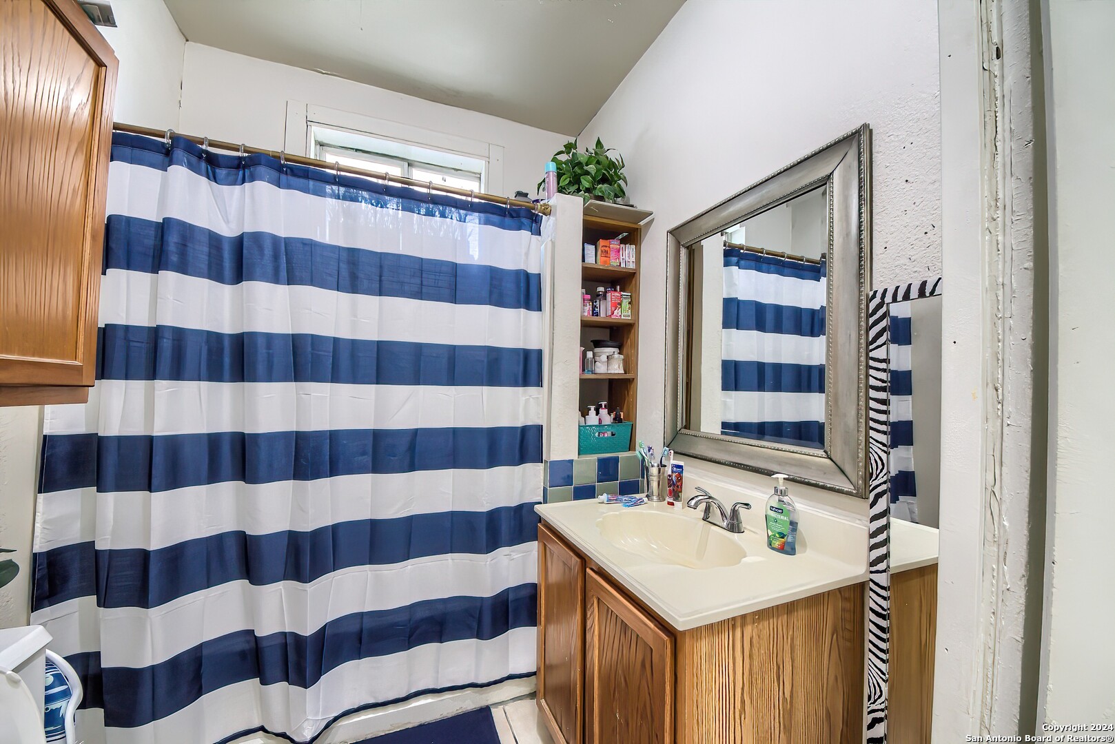 211 Blanco Road San Antonio, TX 78212 - Photo 30 of 34 a bathroom with a sink a mirror and a shower