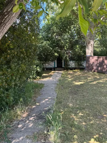 a view of patio with a table and chairs under an umbrella