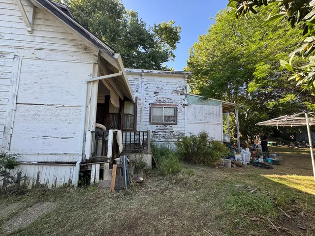 a view of a house with a yard and sitting area