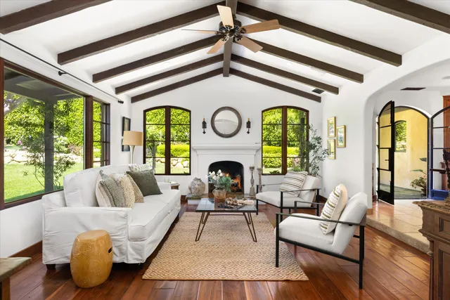 a living room with fireplace furniture and a large window