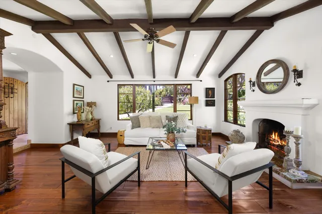 a living room with fireplace furniture and a large window