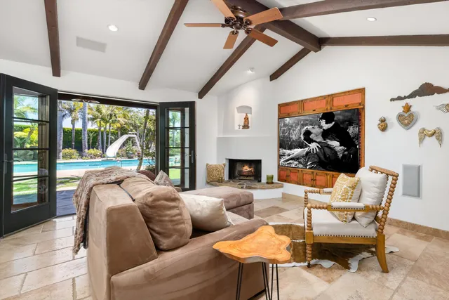 a living room with furniture a fireplace and a floor to ceiling window