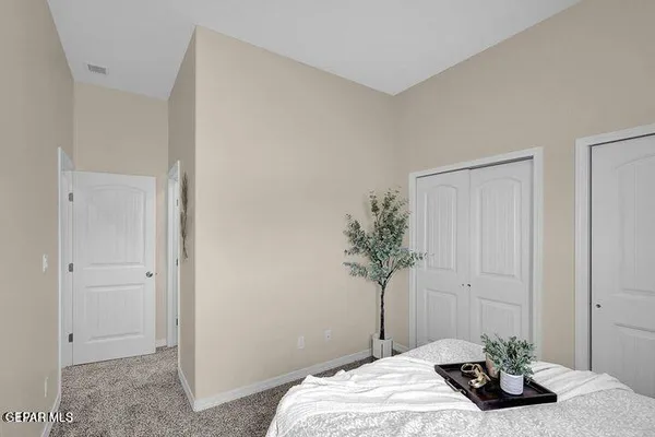 a bedroom with a bed and a potted plant