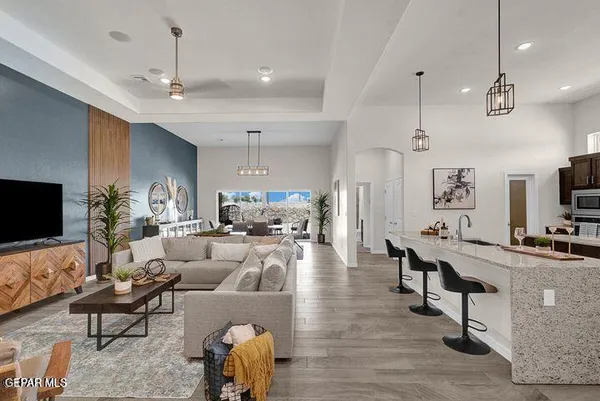 a living room with furniture a flat screen tv and kitchen view