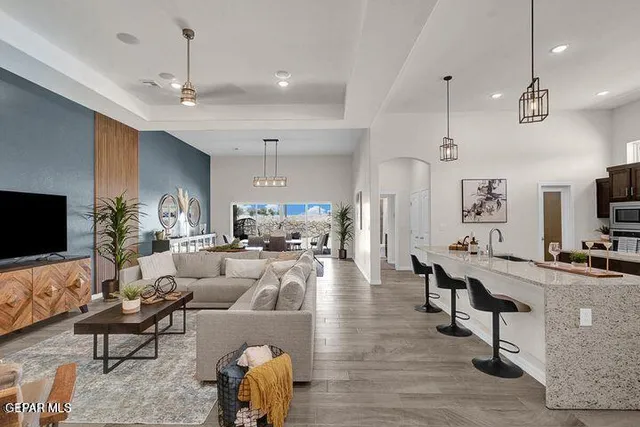 a living room with furniture a flat screen tv and kitchen view
