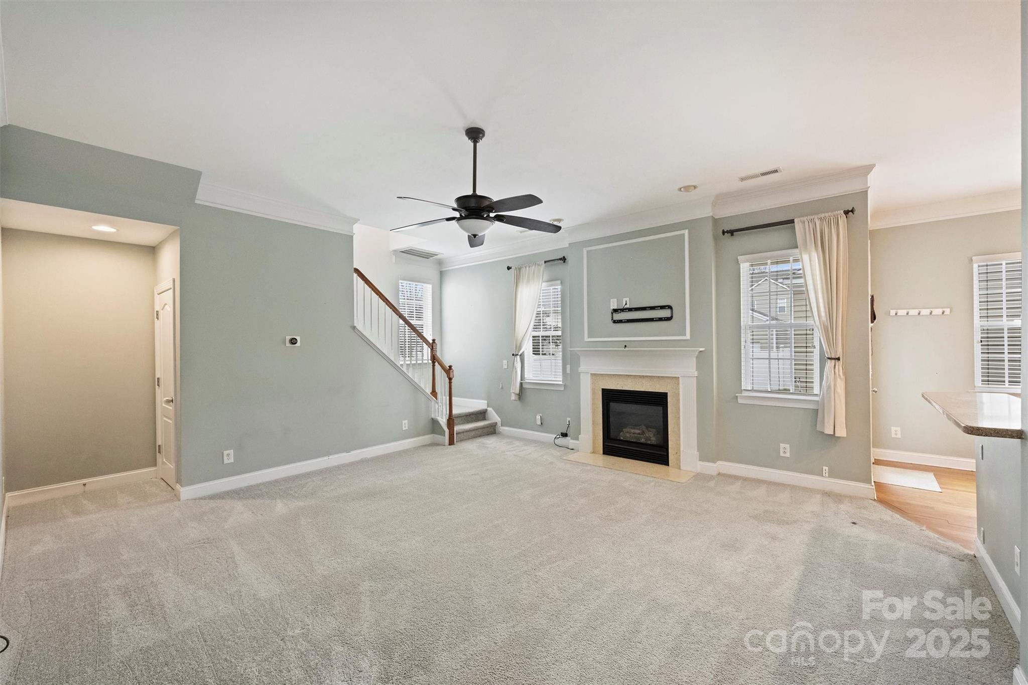 10513 Serape Road Charlotte, NC 28277 - Photo 12 of 45 a view of a livingroom with a fireplace a ceiling fan and windows