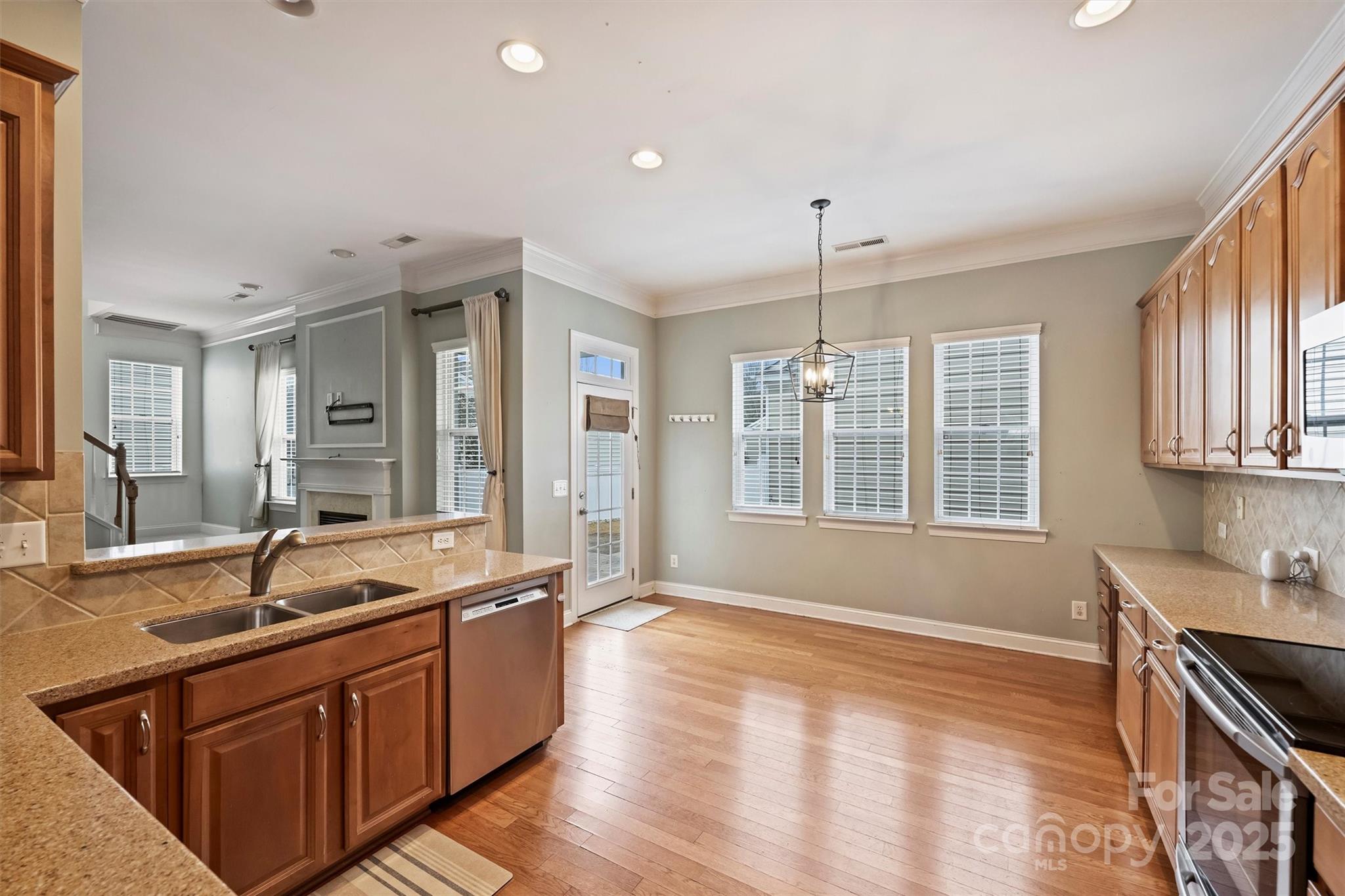 10513 Serape Road Charlotte, NC 28277 - Photo 23 of 45 a large kitchen with kitchen island a sink wooden floor and a large window