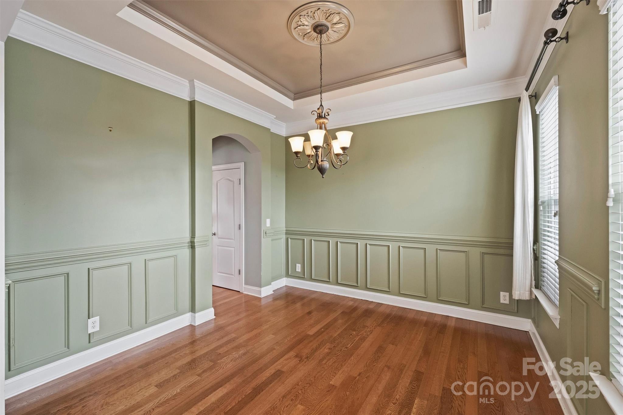 10513 Serape Road Charlotte, NC 28277 - Photo 10 of 45 a view of a hallway with wooden floor and chandelier