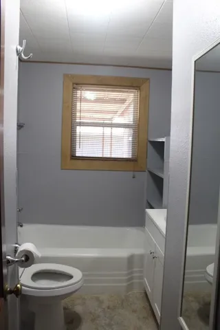 a bath room with a toilet and a bath tub