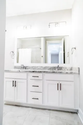 a bathroom with a sink vanity and a mirror