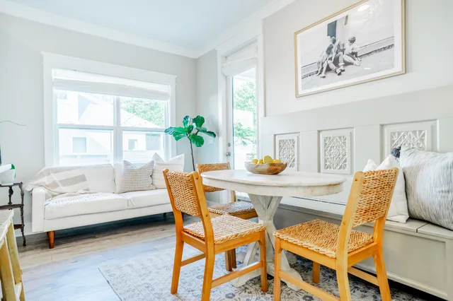 a living room with furniture a dining table and a potted plant
