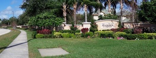 6552 Moorings Point Circle, Unit 102 Lakewood Ranch, FL 34202 - Photo 57 of 57 a view of a park that has a sign board with palm trees